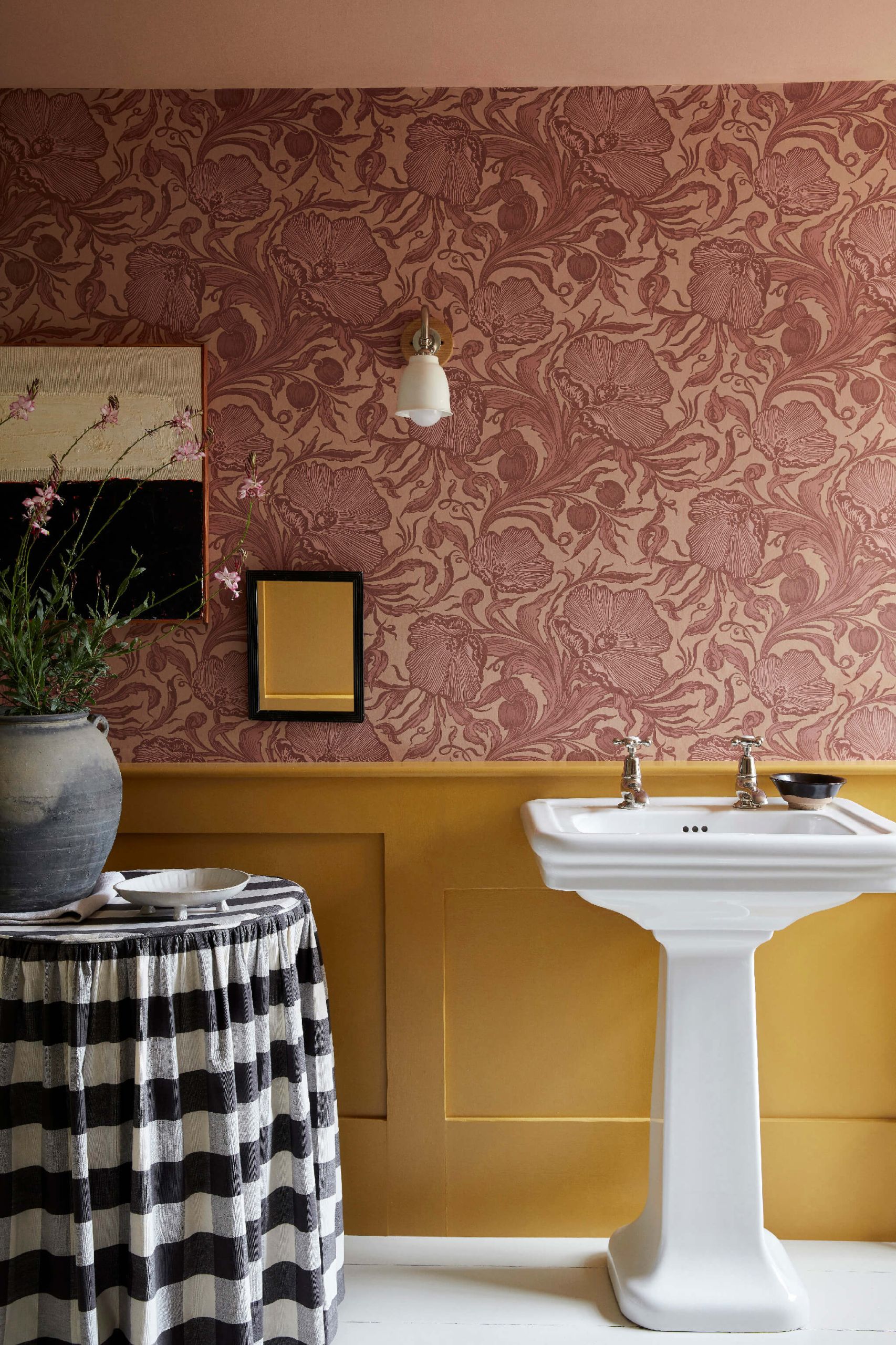 Bagno con carta da parati damascata rosa antico e boiserie gialla, lavabo a colonna