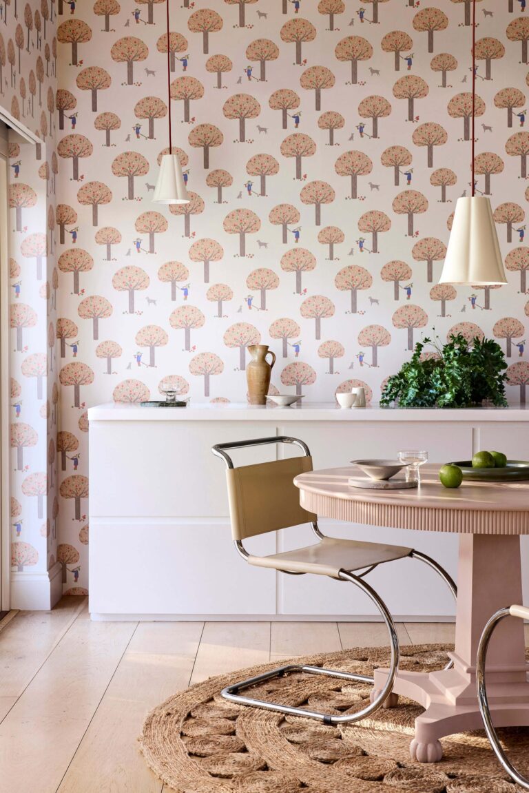 Sala da pranzo rosa con carta da parati a funghi stilizzati e tavolo tondo