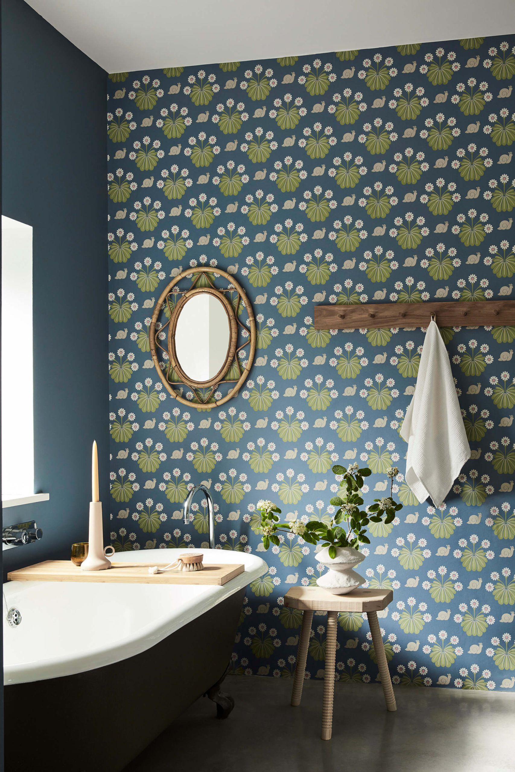 Bagno azzurro con carta da parati floreale, vasca freestanding e specchio ovale