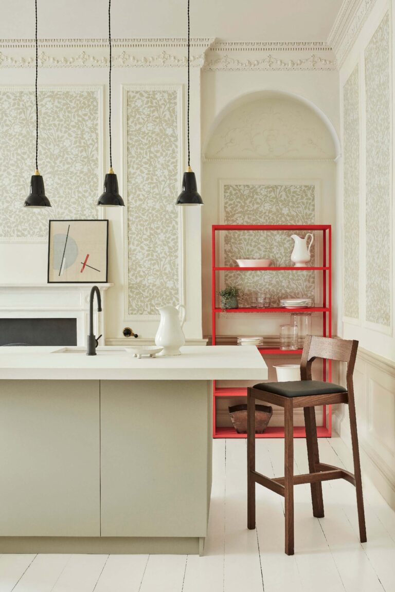 Cucina chiara con carta da parati tono su tono e lampade a sospensione nere
