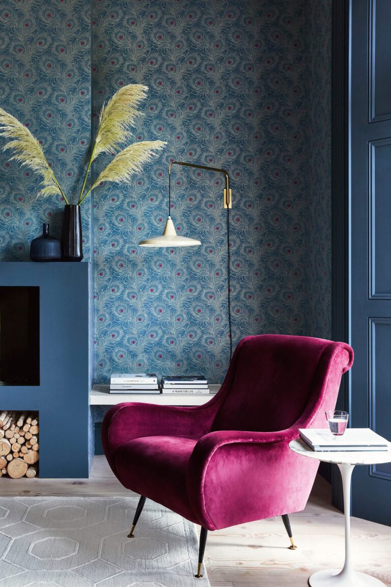 Soggiorno blu con carta da parati damascata e poltrona fucsia