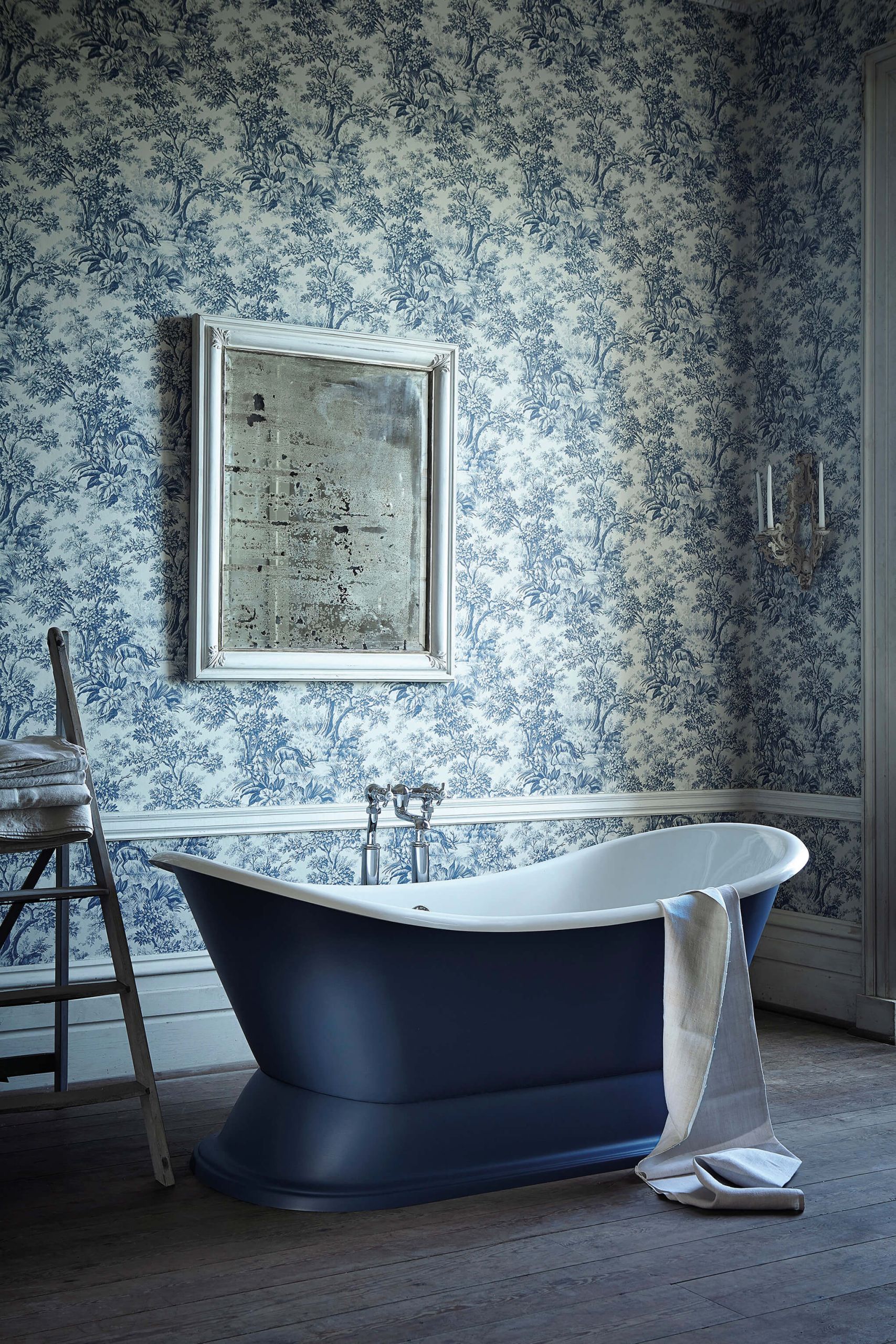 Bagno con carta da parati toile azzurra e vasca freestanding blu notte