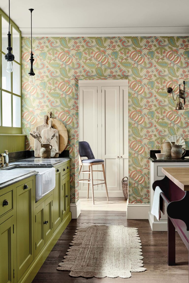 Cucina verde con carta da parati a melograni e mobili in tinta
