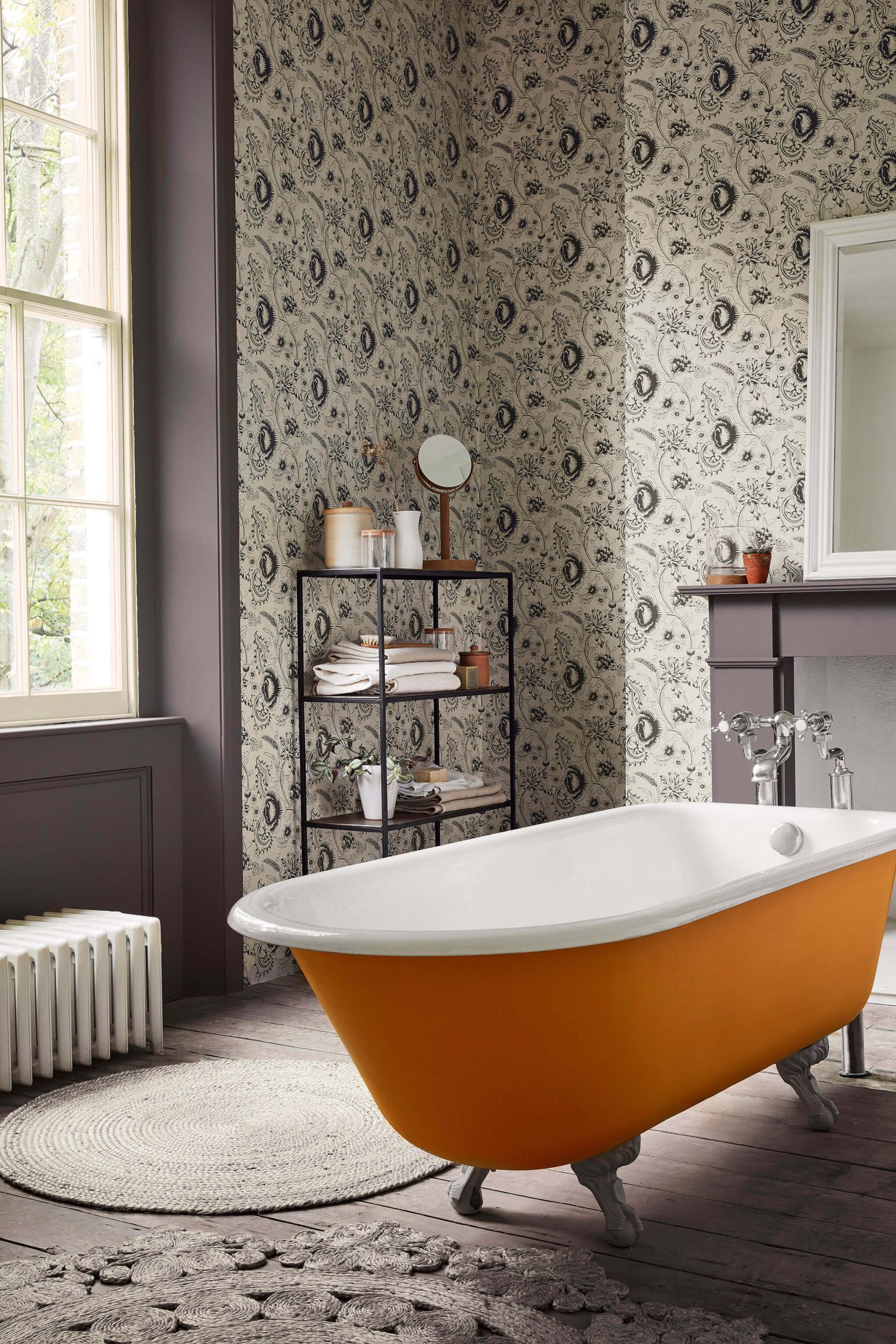 Bagno con carta da parati woodblock nei toni del grigio e vasca freestanding arancione