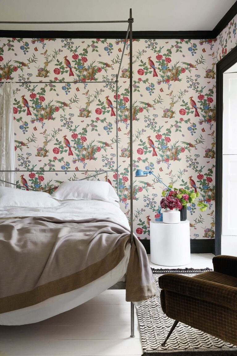 Camera da letto con carta da parati a uccelli e fiori su fondo crema e letto a baldacchino