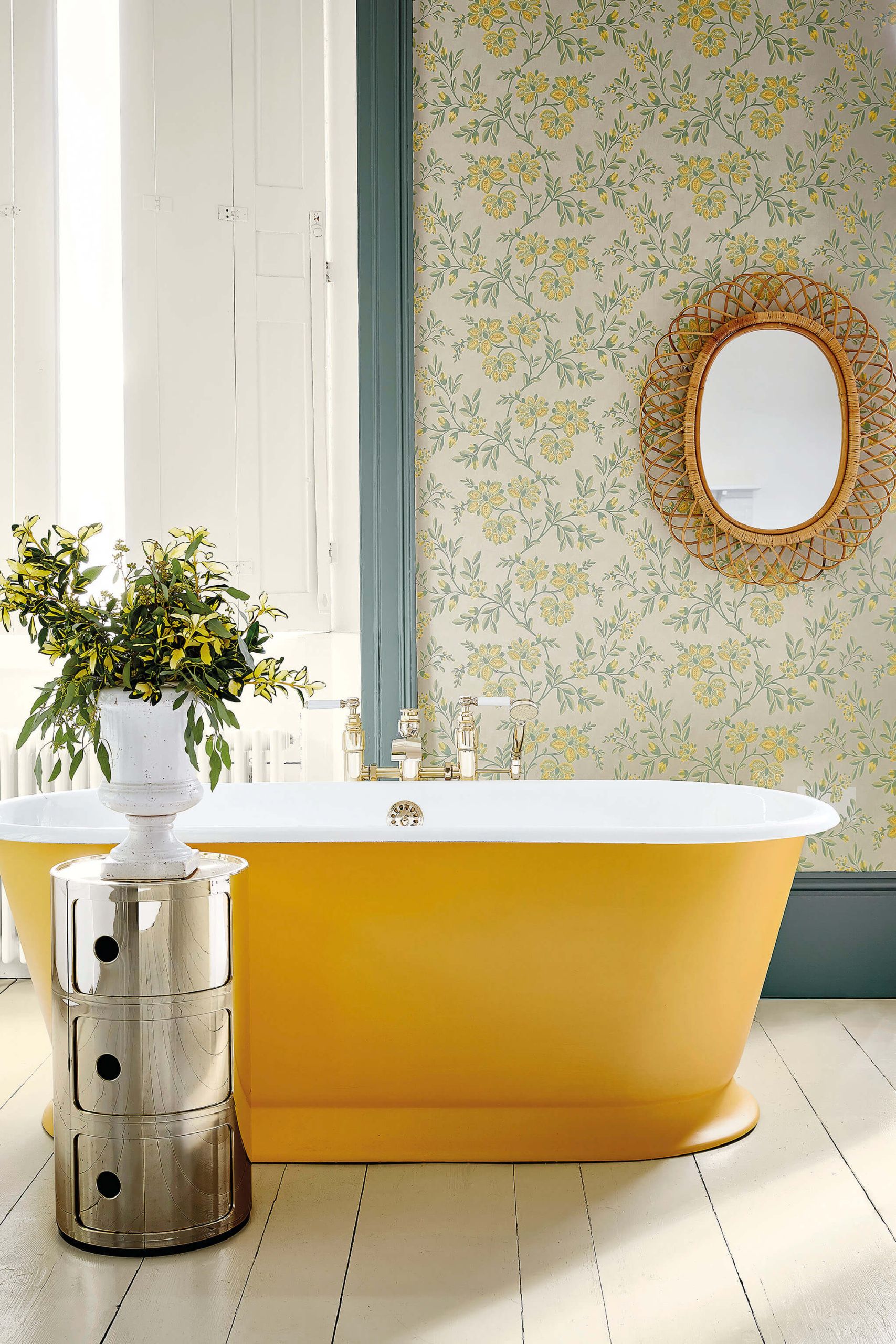 Bagno luminoso con carta da parati floreale chiara e vasca gialla