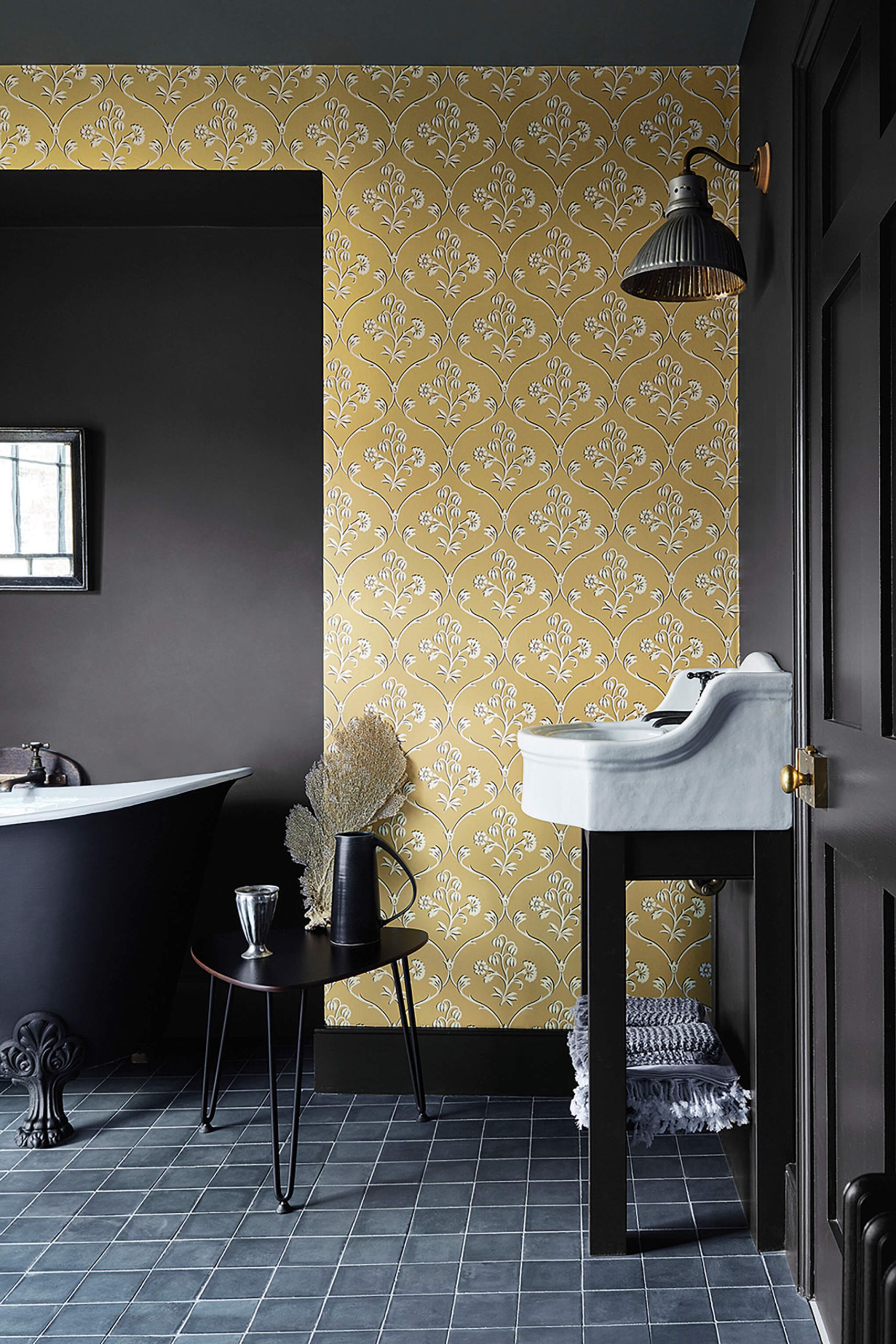 Bagno scuro con carta da parati damascata senape e pavimento in ardesia