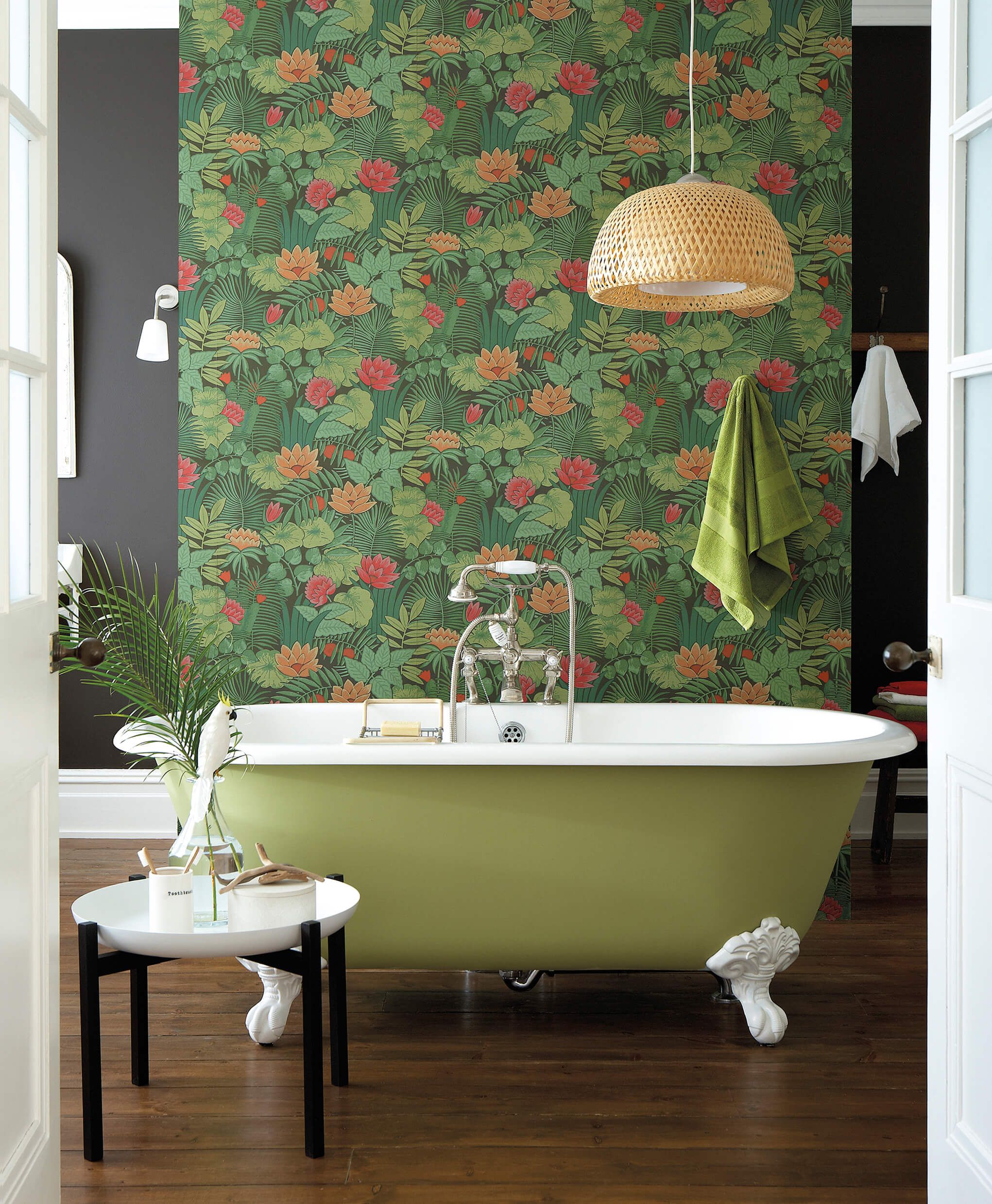 Bagno con carta da parati a motivo jungle verde e vasca freestanding oliva